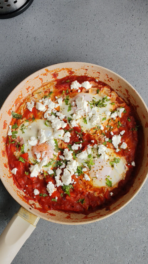 Shakshuka servirana u tiganju. sa feta sirom i svezim korijandorom