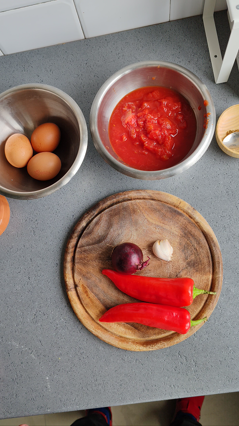 Sveži sastojci zashakshuku: paprika, luk, beli luk na rustičnoj drvenoj dasci.